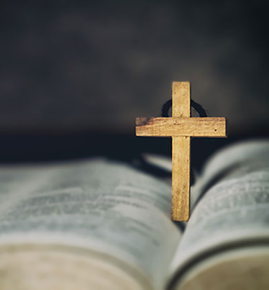 an older carpenter, like Jesus, shaving wood with a plane