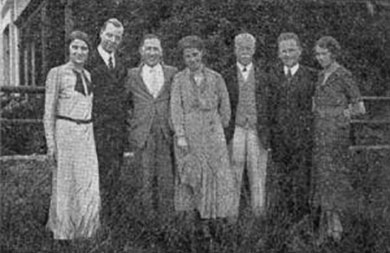 a black and white image of Smith Wigglesworth preaching pointing with his right index finger while reading from a Bible in his left hand