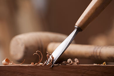 antique carpentry hand tools on a wooden table in an old barn with a beam of sunlight shining on them
