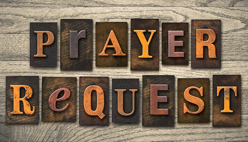  old vintage typsetting blocks spelling out prayer request on a grey wooden table